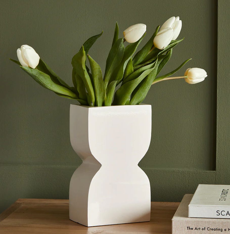 egg-timer shaped white vase with white tulips