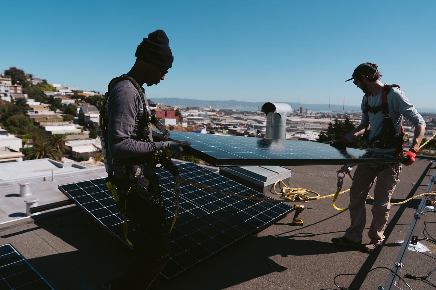 Workers install solar panels on a home in San Francisco.
