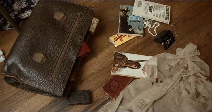 This may contain: the contents of a purse are on the floor next to books and other items that have been placed around it
