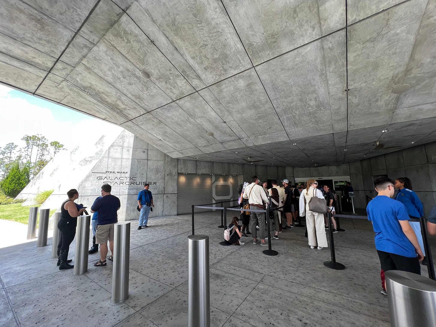 People queuing in a grey concrete foyer