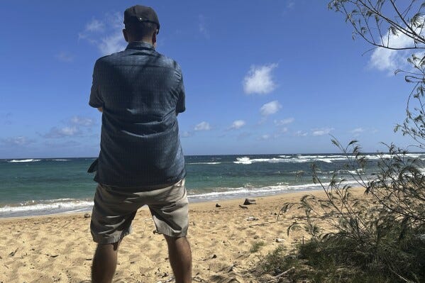 Antonio Perez looks out at Kawailoa Bay in Kauai, Hawaii on Nov. 5, 2023. “I was suicidal before I got into conspiracy theories,” said Perez, who became obsessed with Sept. 11 conspiracy theories and QAnon until he decided they were interfering with his life. Back then, when he first found other online conspiracy theorists, he was ecstatic. “It’s like: My God, I’ve finally found my people!” (AP Photo/Eugene Garcia)
