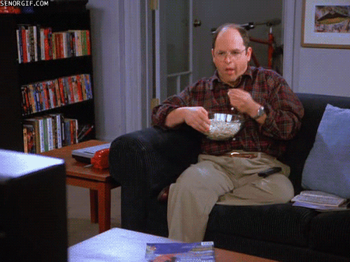 George Costanza of Seinfeld eating popcorn while watching TV.
