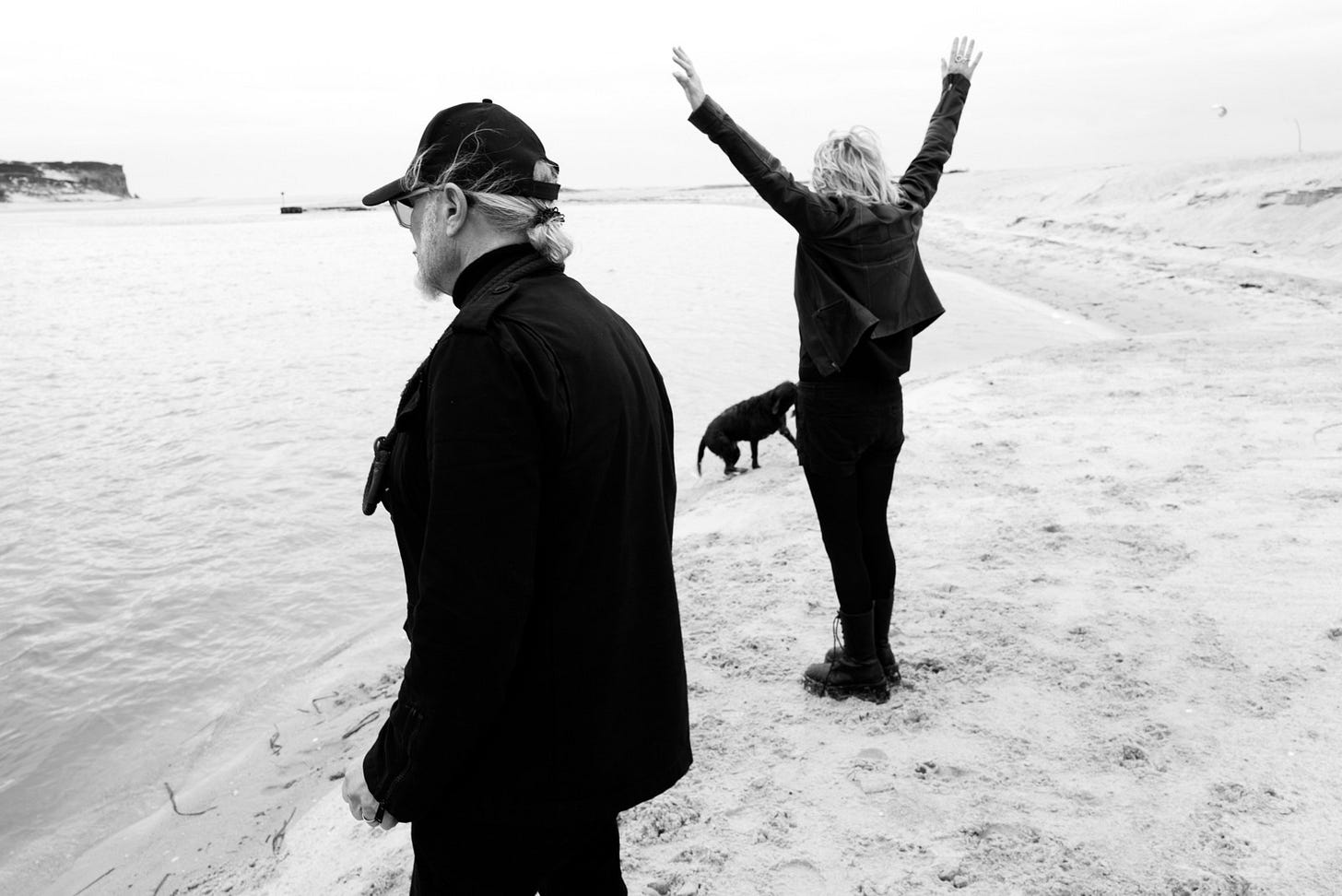 Man and woman with hounds on a beach