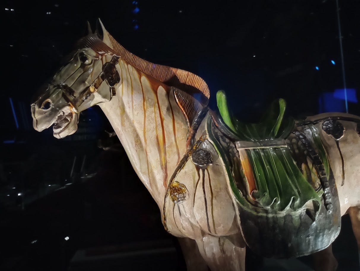 Large ceramic horse with red paint running from its mane