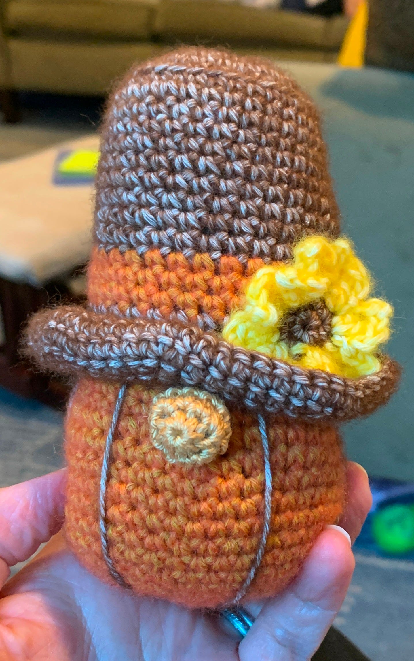 up close of a crochet gnome with a grown tophat in fall colors