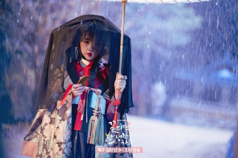 A kisaeng in a veil with an umbrella in the rain