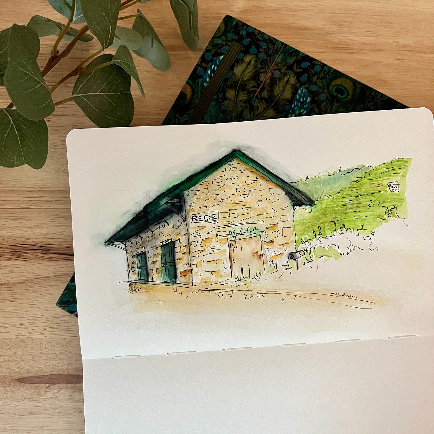 image: ink and watercolour painting of an unused old train station with rustic brick walls, green roof and the majestic mountains in the foreground