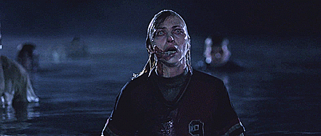 [gif: I’m feeling peckish.] a female zombie with a scary jaw emerges from the water, baring her teeth.
