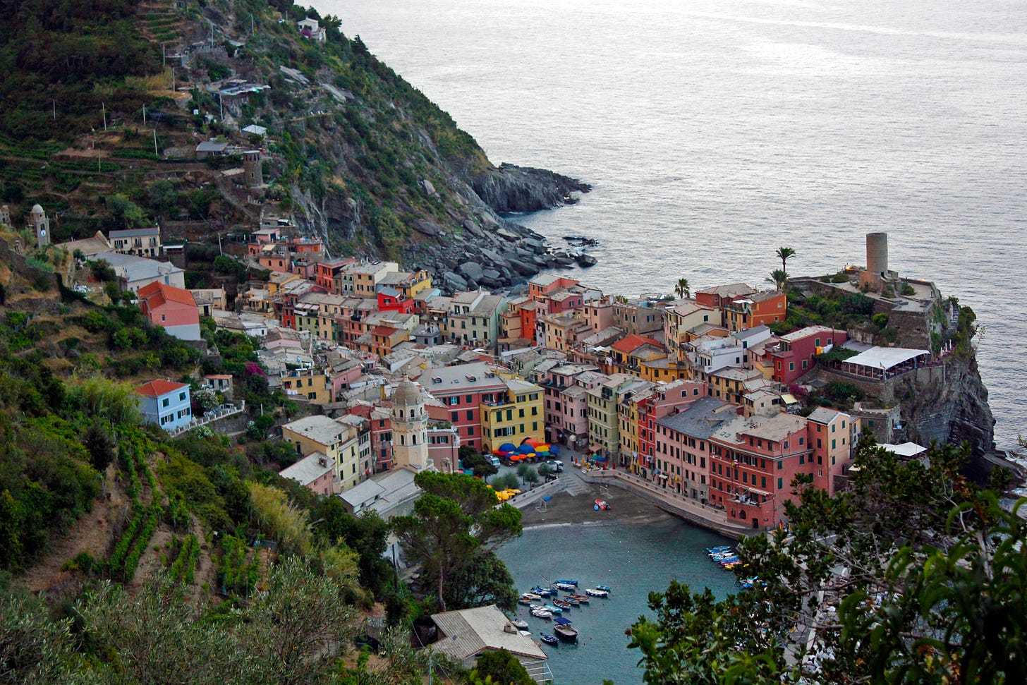 Vernazza, Italy, seen from the hillside above. It's a small town of colorful buildings on the seaside.