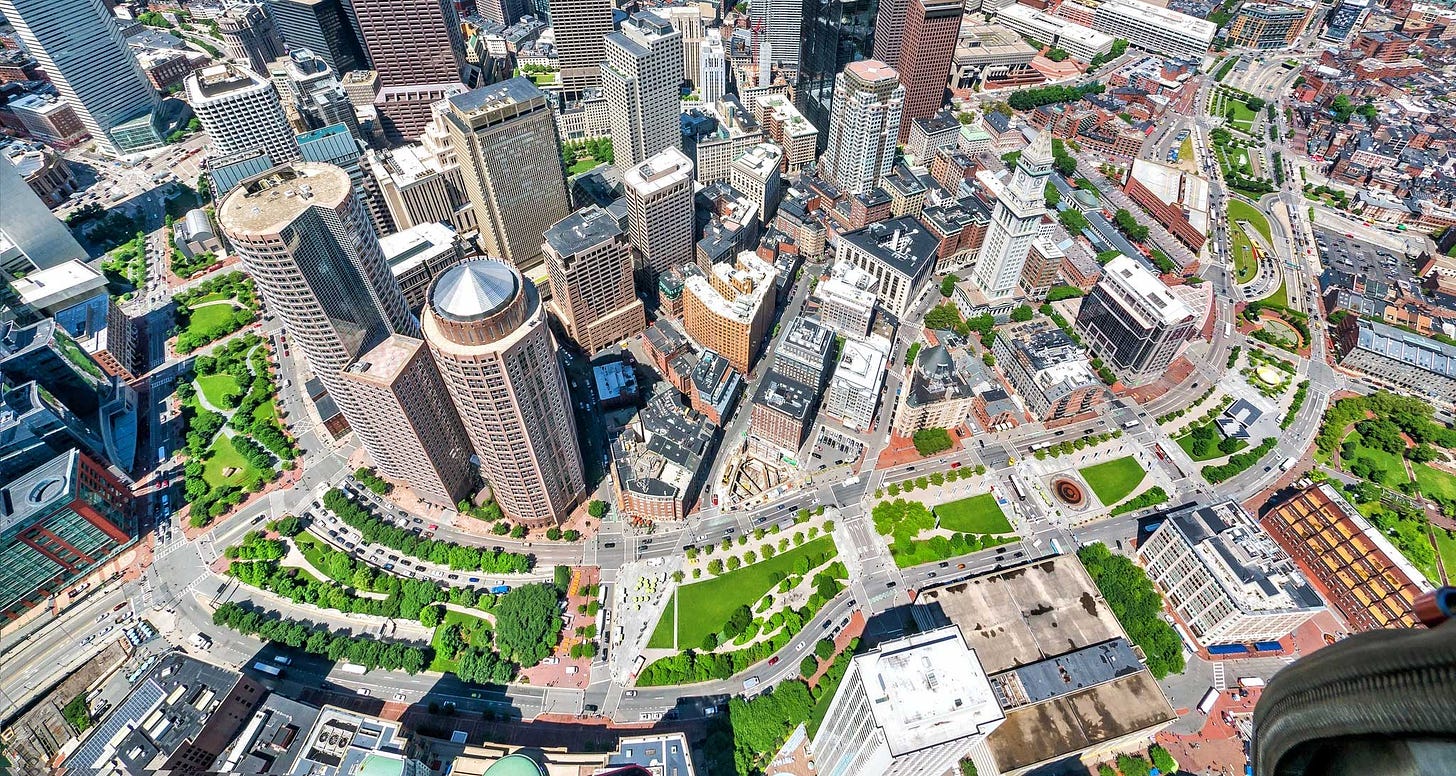 Aerial view of greenway winding through downtown Boston cityscape.