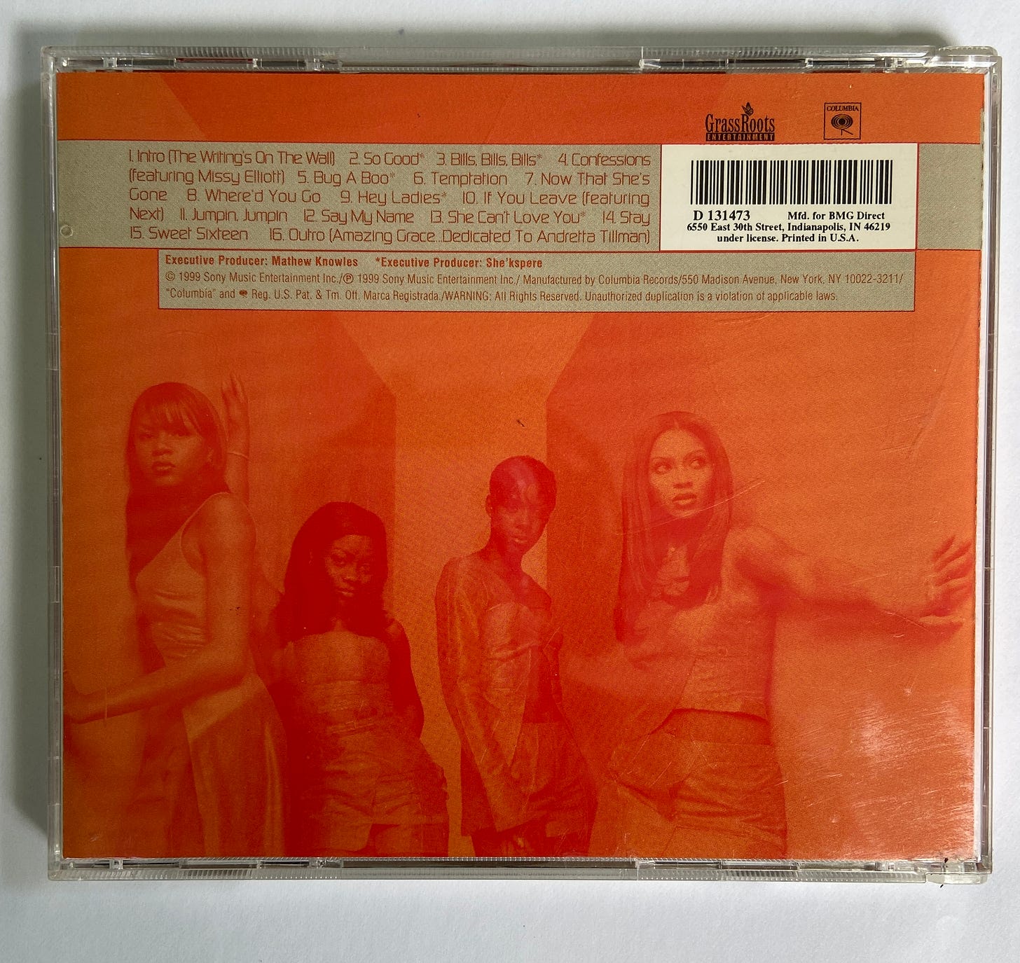 the back cover for the CD The Writing's on the Wall by Destiny's Child. four young Black women poses next to wall with orange filters over them. the album tracklist and credits appear above their heads.