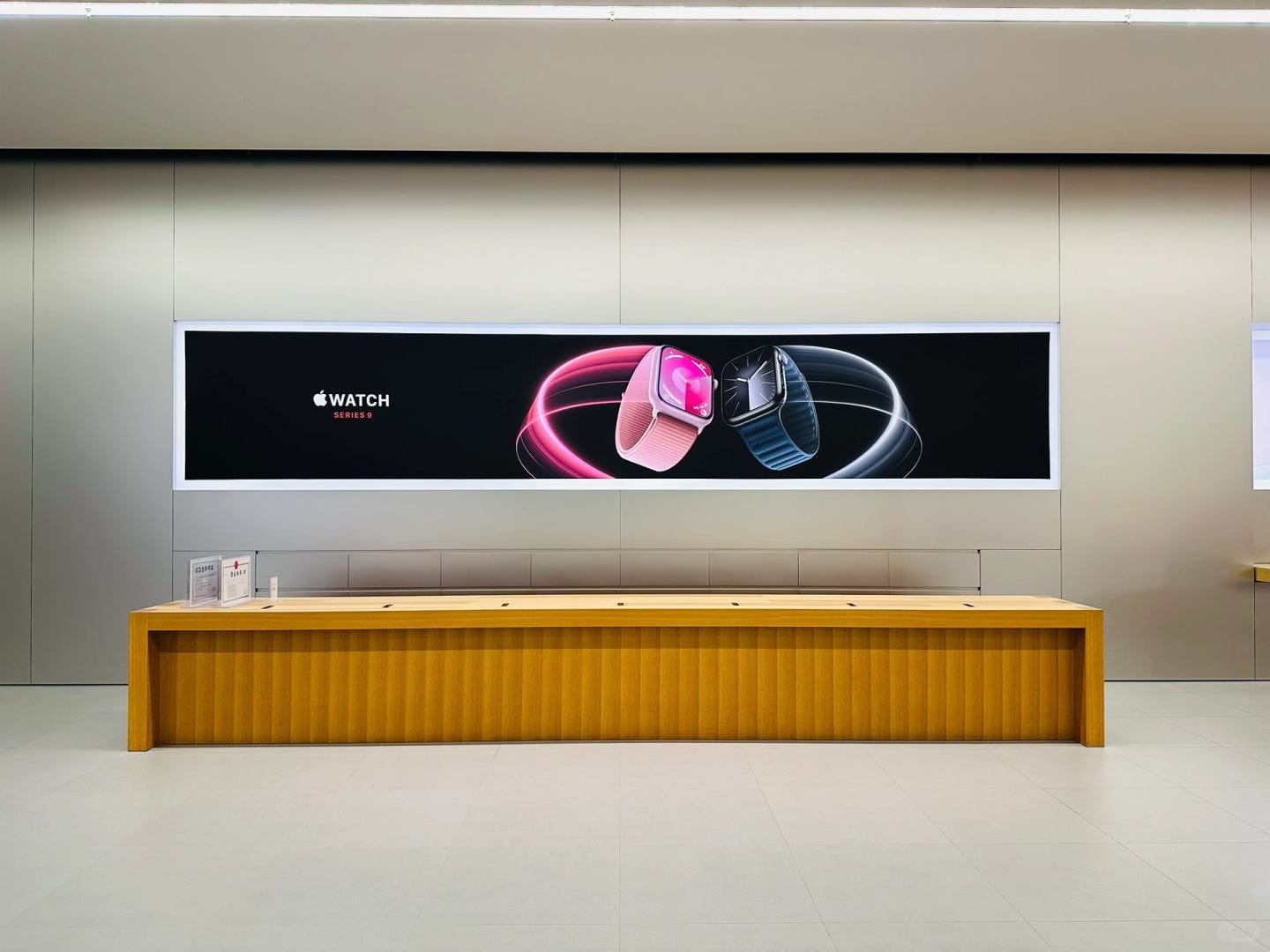 The Express Counter at Apple Jiefangbei. A large Apple Watch Series 9 graphic panel fills the wall.