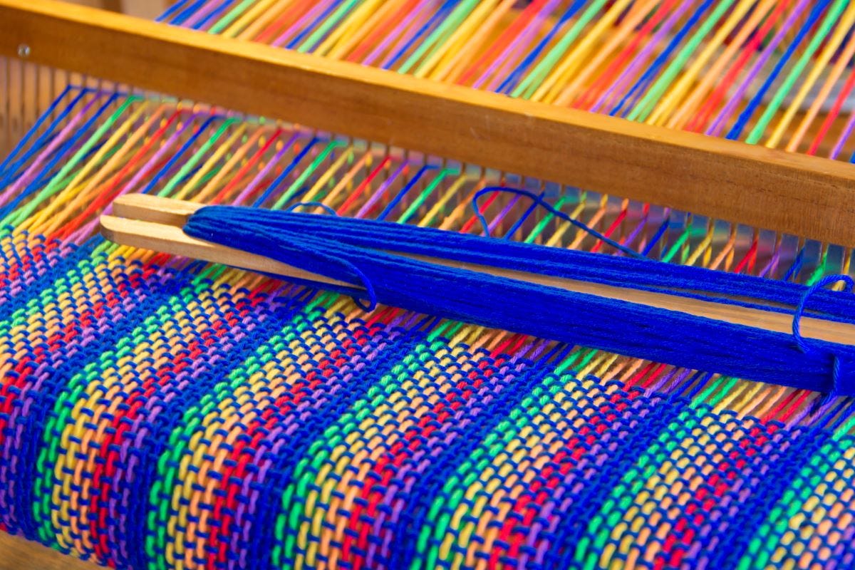 Colorful cloth being woven on a hand loom