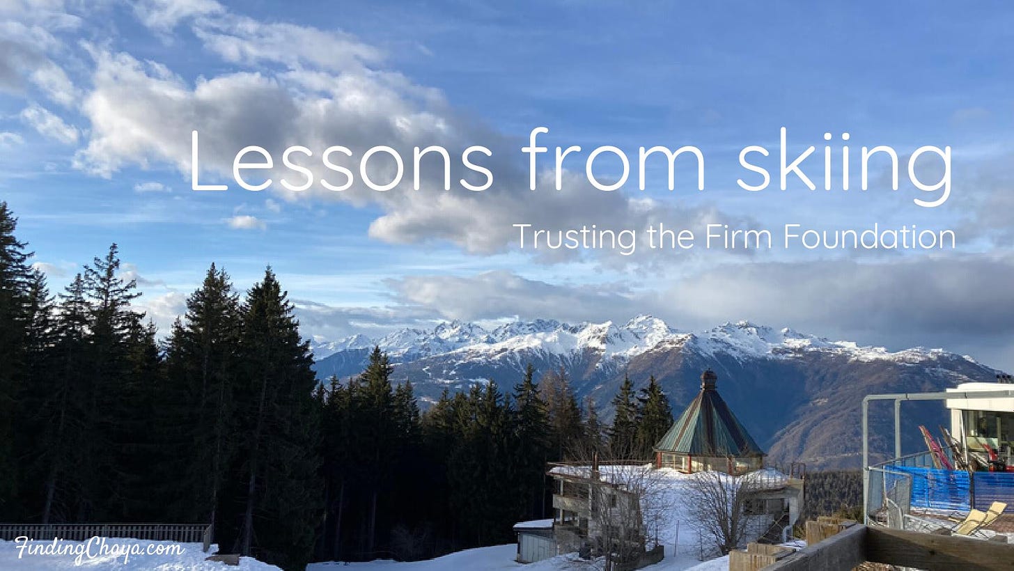 View of the Italian mountains from a cafe in the mountains. Blue sky with clouds and pine trees can be seen. Text over the top reads "Lessons from skiing: Trusting the Firm Foundation.