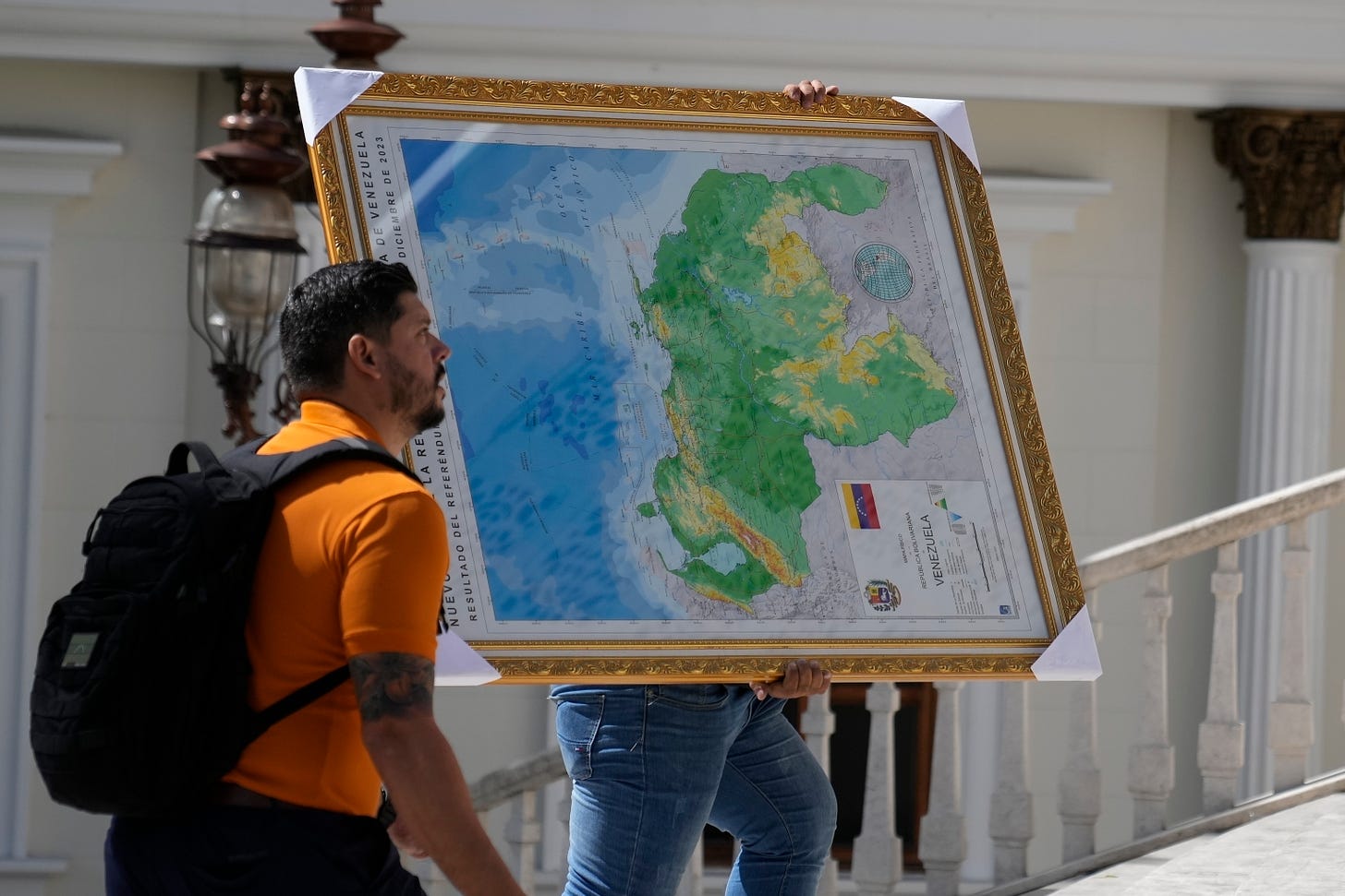 Un hombre carga un mapa de Venezuela que incluye el territorio de Esequibo.