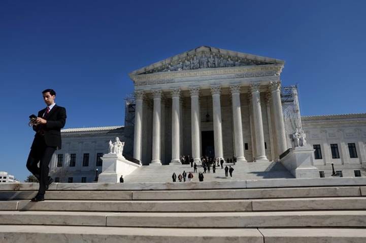 A large white building with columns with United States Supreme Court Building in the background

Description automatically generated
