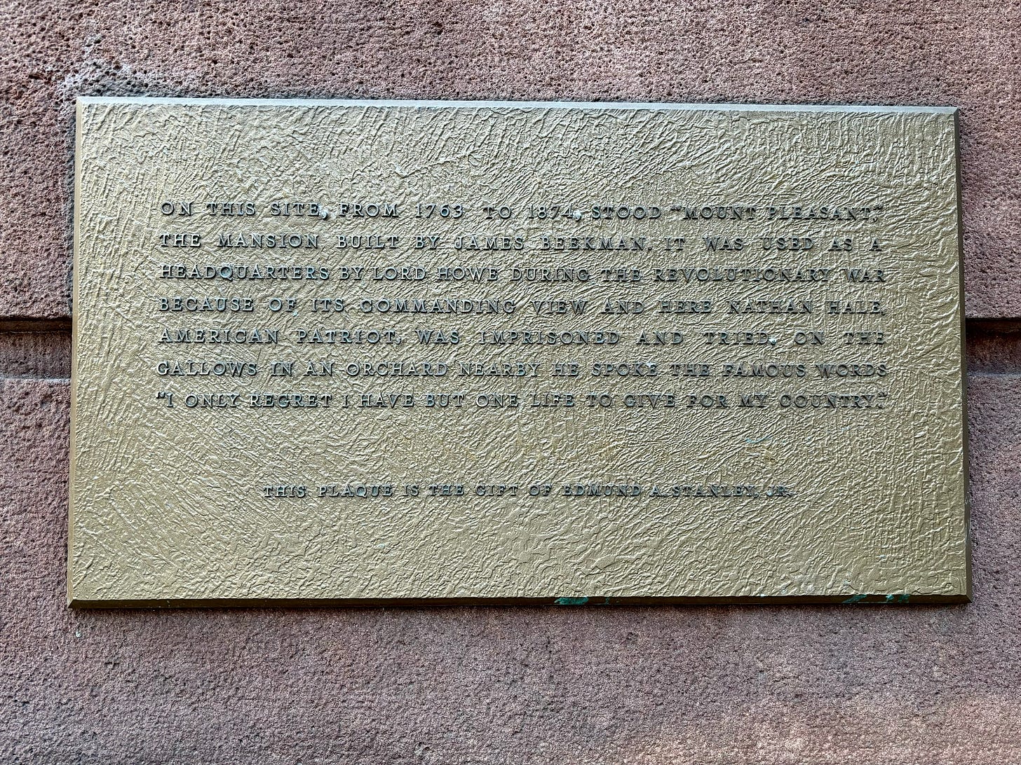 A close-up of the plaque on what was once James Beekman's summer mansion. It reads: On this site, from 1763 to 1874, stood “Mount Pleasant”, the mansion built by James Beekman. It was used as a headquarters by Lord Howe during the Revolutionary War because of its commanding view and here Nathan Hale, American patriot, was imprisoned and tried. On the gallows in an orchard nearby he spoke the famous words “I only regret I have but one life to give for my country.”  This plaque is the gift of Edmund A. Stanley, Jr.