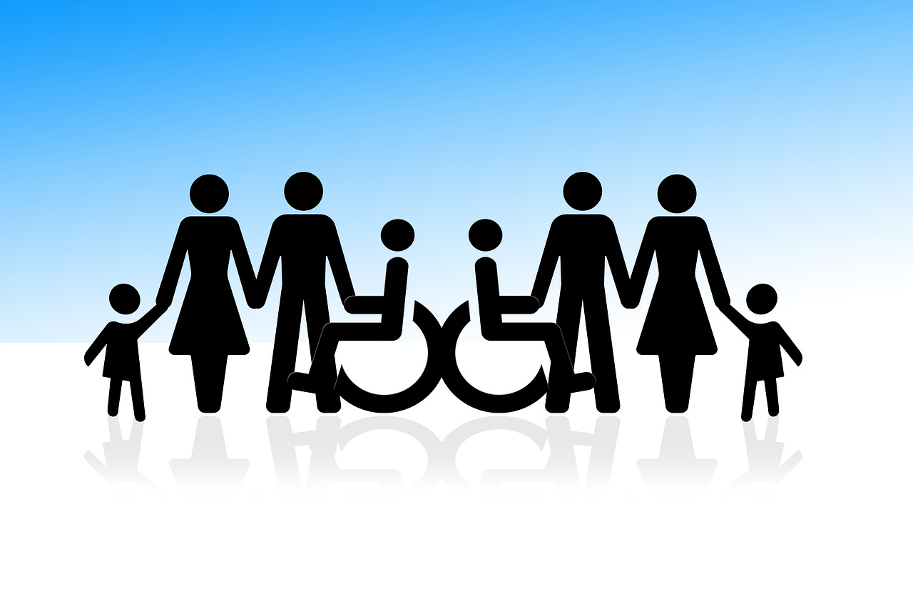 an image of people holding hands, including two people who are wheelchair users