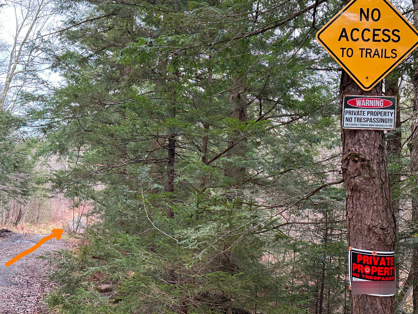 The trail and adjacent signage indicating its private property, even though it is not.