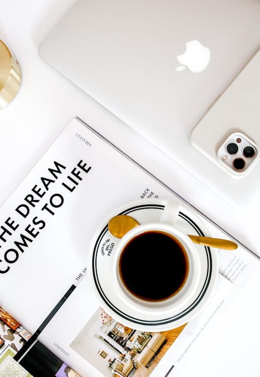 Free Top view of a modern workspace featuring coffee, a MacBook, and smartphone. Stock Photo