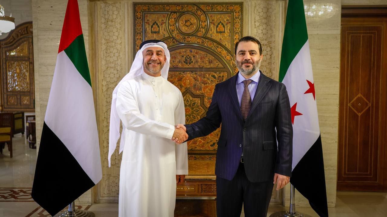 Two men shaking hands in front of flags

AI-generated content may be incorrect.