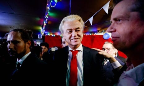 Geert Wilders smiles as a man puts a hand on his shoulder