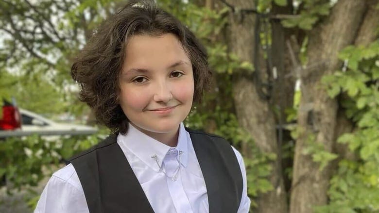 A photograph of a teenager smiling.