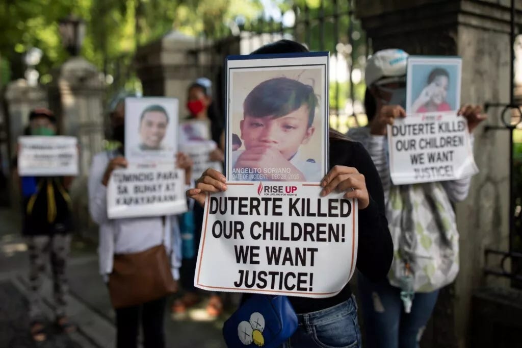 Relatives of drug war victims hold photographs of their slain loved ones with placards calling for justice, during a protest to commemorate President Rodrigo Duterte's final year in office, Manila, Philippines, 30 June 2021 (Photo: Reuters/Eloisa Lopez).