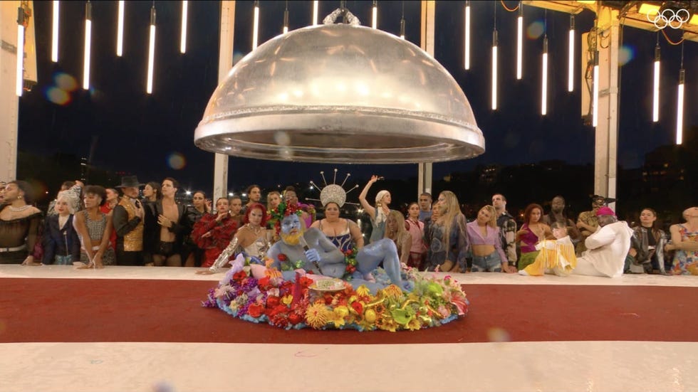 a group of people sitting on a stage with a large circular object in the back