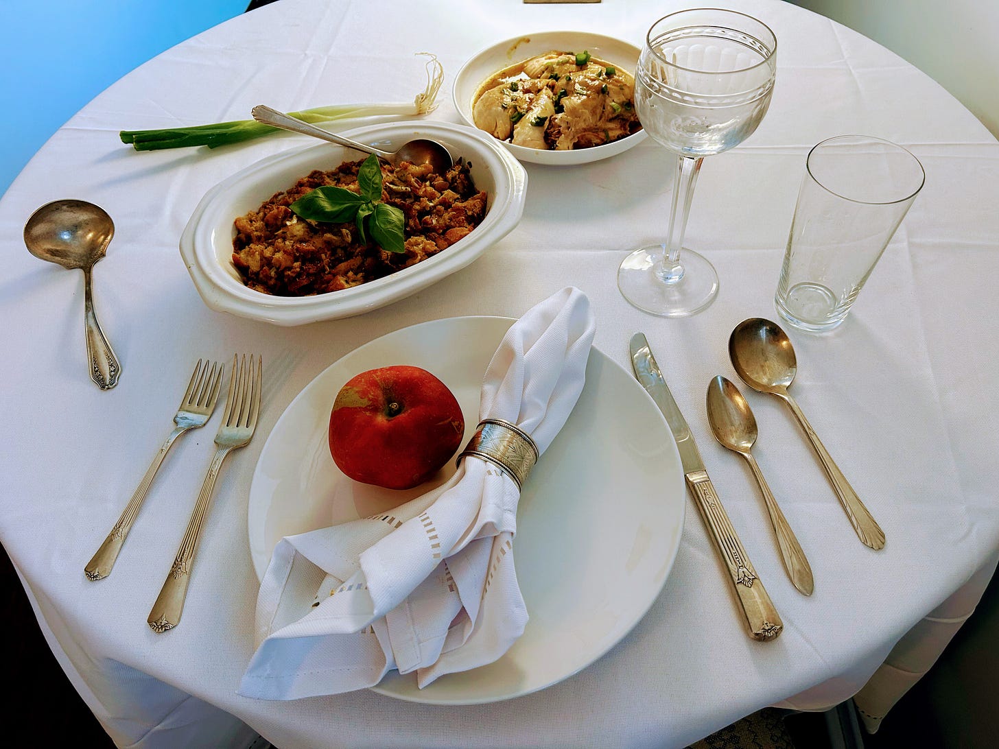 Food on a table with a white table cloth.