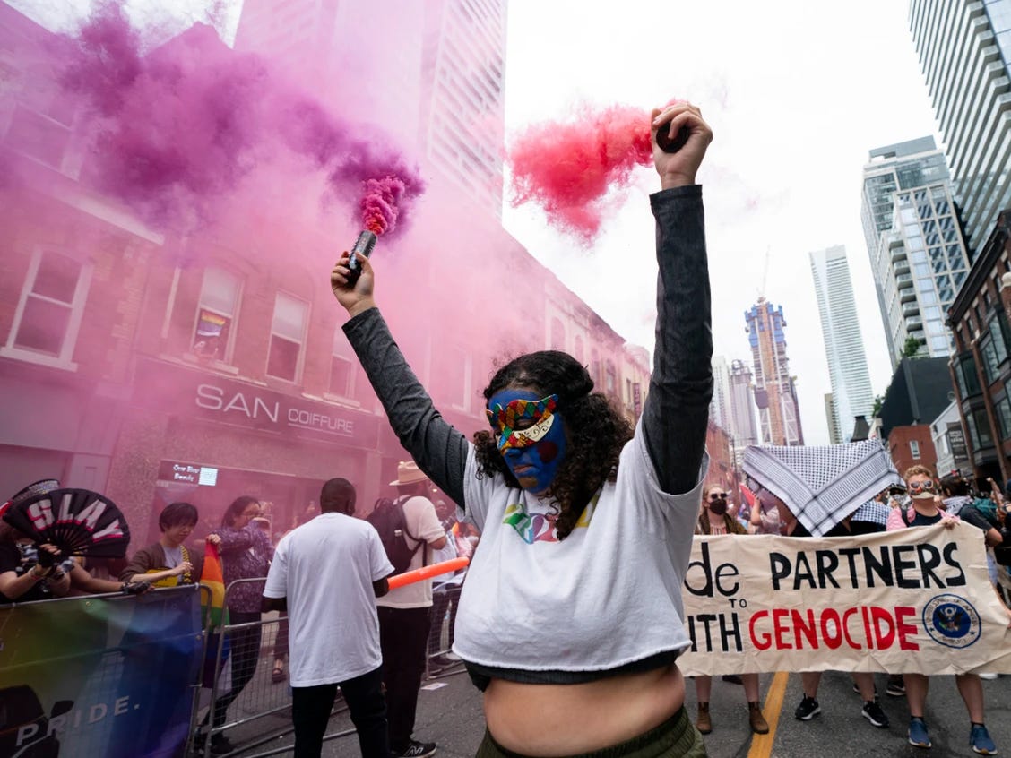 A person holding smoke bombs in the street

Description automatically generated