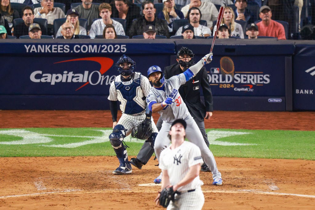 A photo of Teoscar Hernandez smacking a double as pitcher Gerrit Cole looks panicked toward the fence