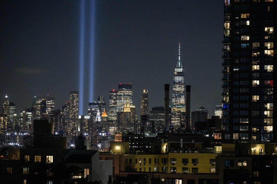 Two pillars of light rise from a New York City skyline.