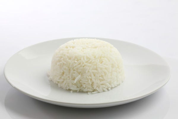 A photo of white rice of a white plate