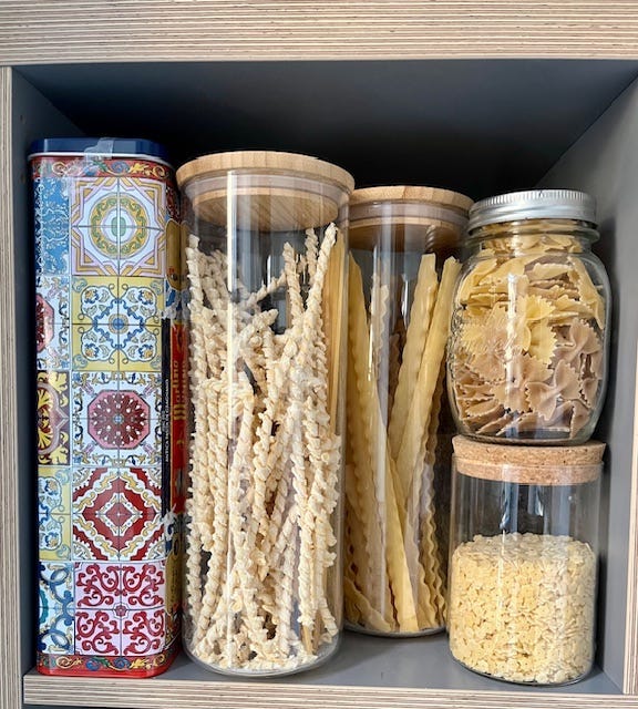 Jars of pasta on a shelf.