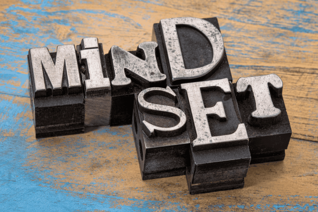 The word mindset spelled out using typesetting blocks on a wooden table.
