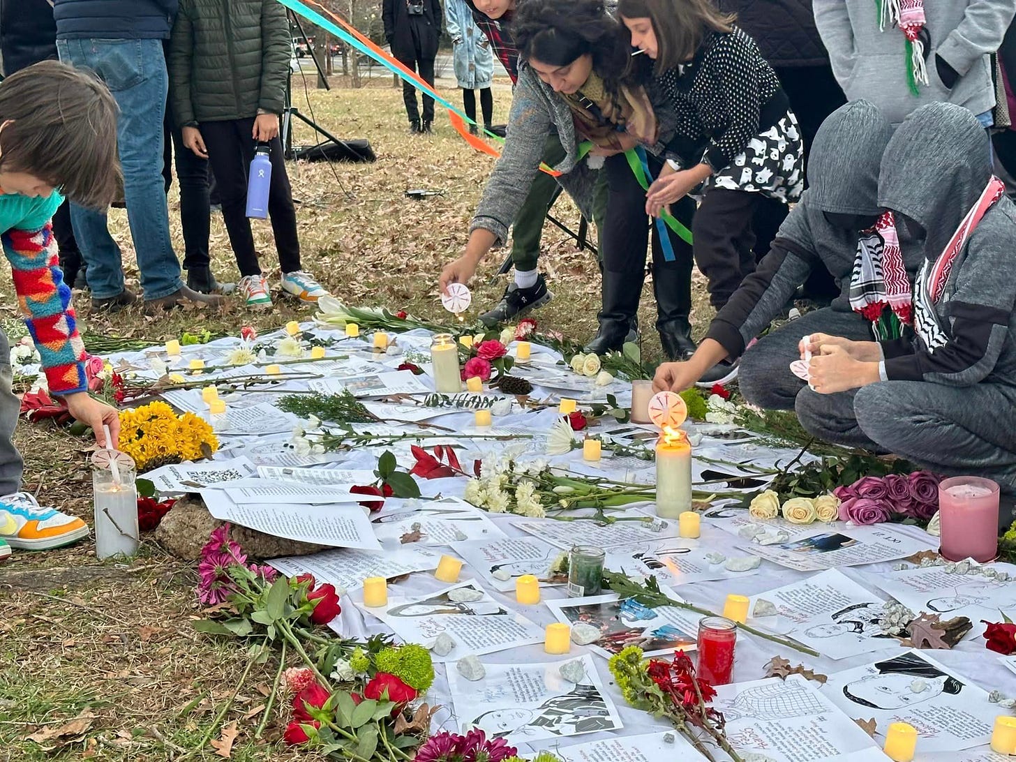 A group of people laying flowers and lighting candles on posters of killed journalists.