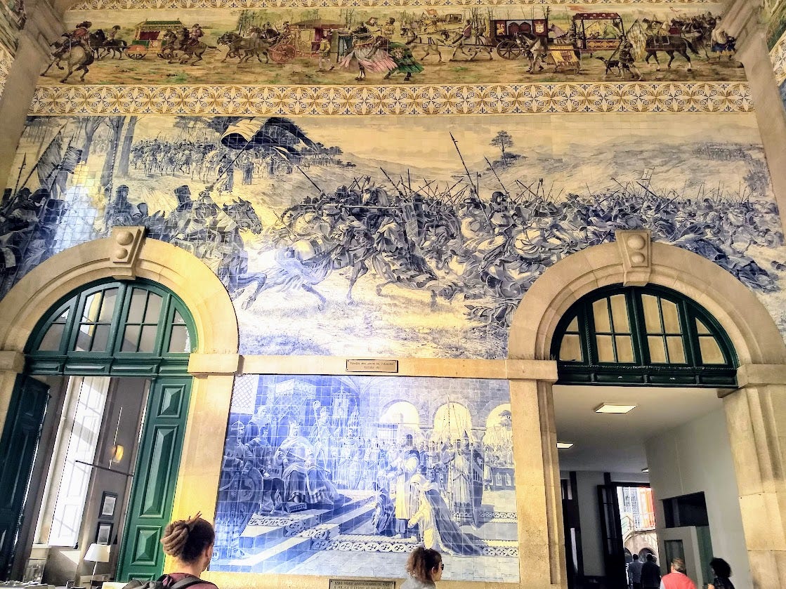 The walls of São Bento station in Porto are covered with tiles that crate massive blue and white pictures.