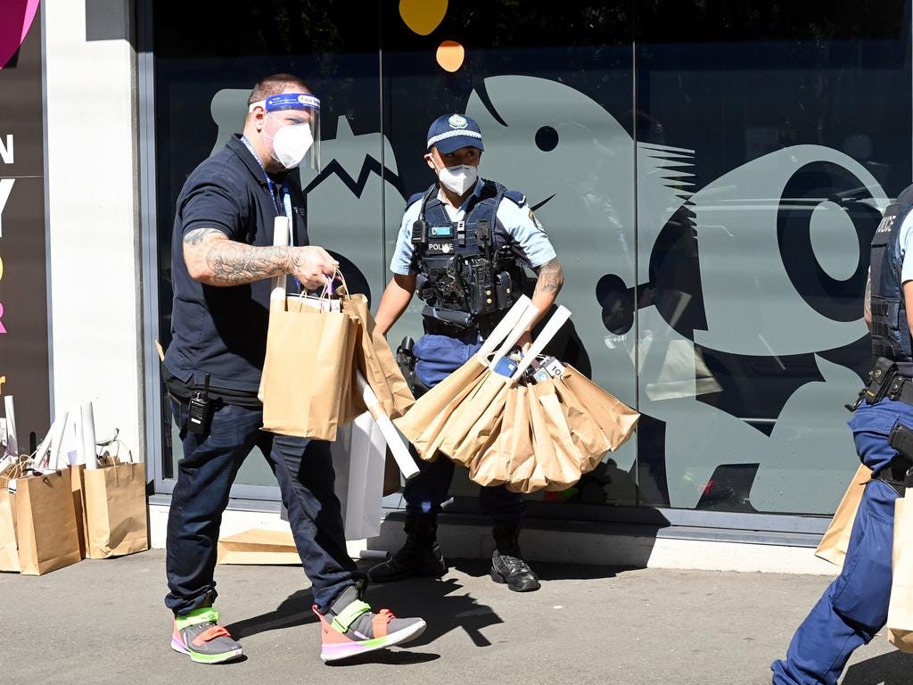 Police help volunteers and support workers carry donated games and food. Picture: NCA NewsWire/Jeremy Piper