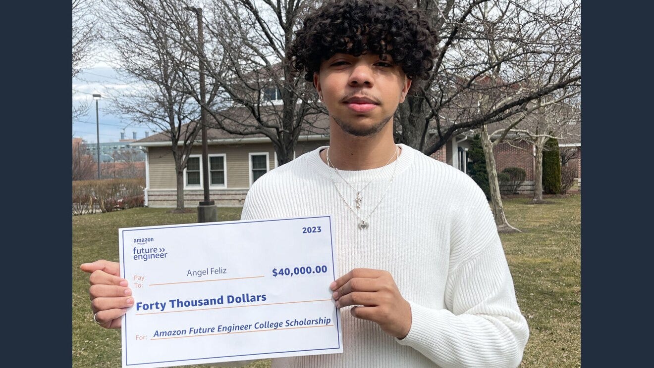 An image of Angel Feliz, a 2023 Amazon Future Engineer Scholarship recipient, holding out his fund check.