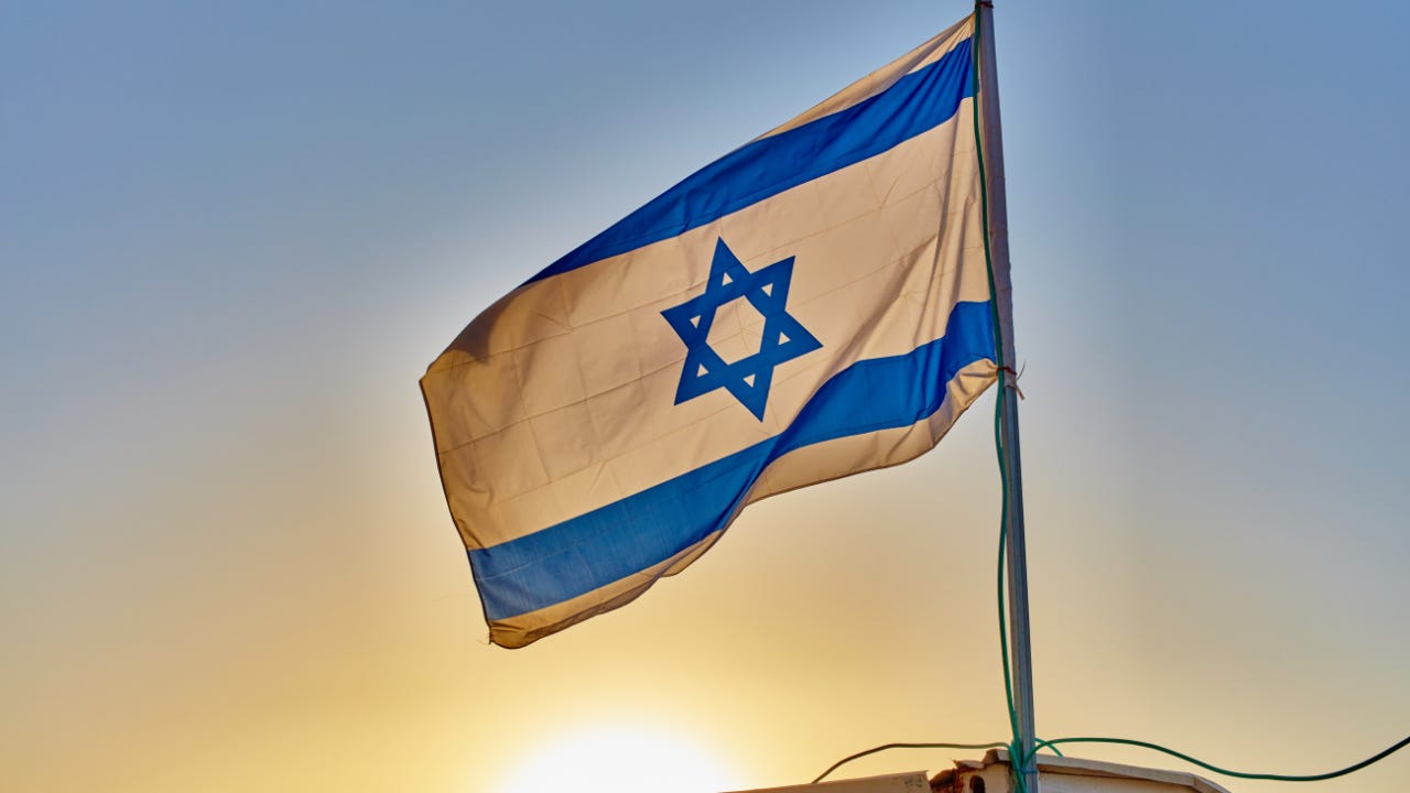 Israel's flag in front of the setting sun.