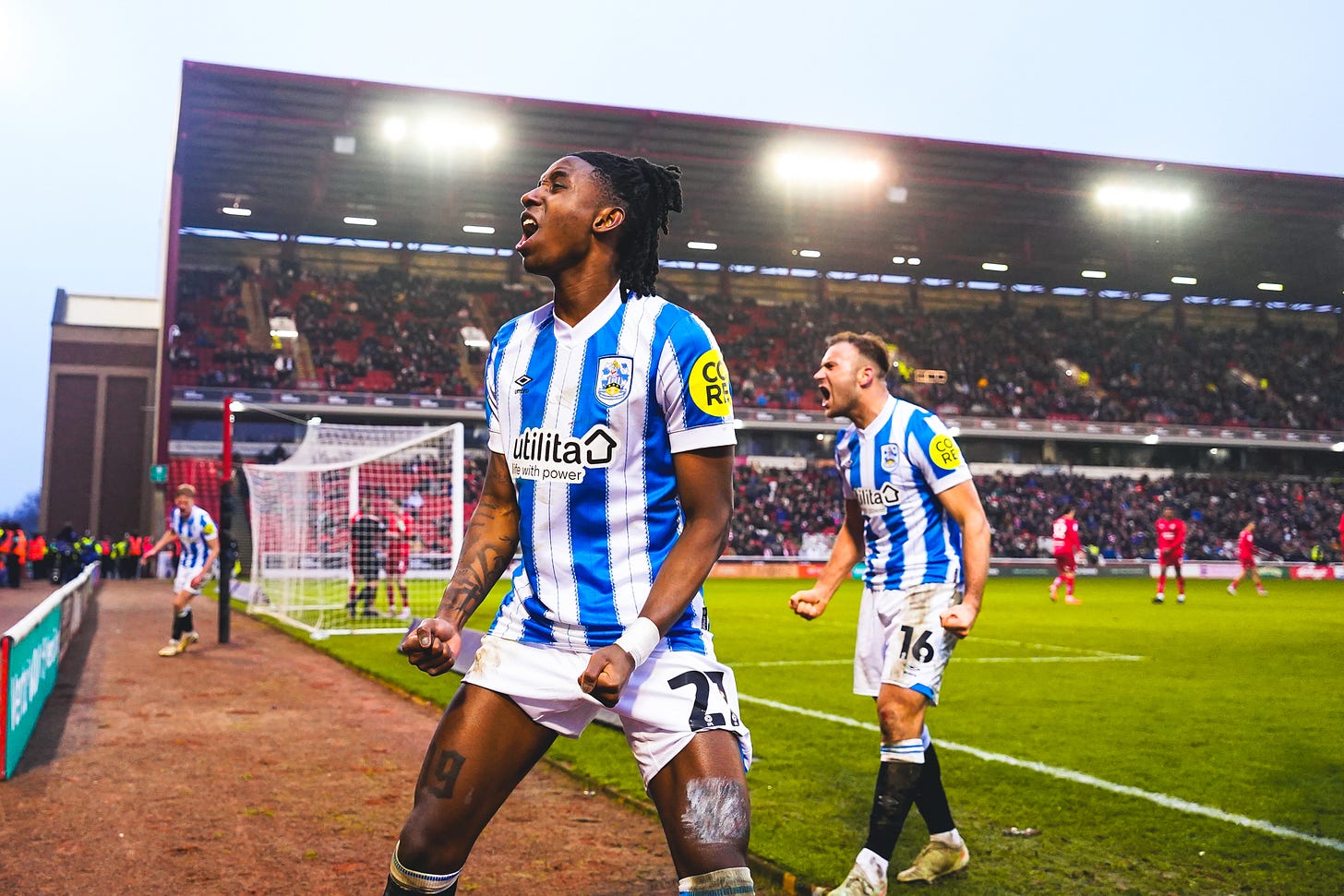 A photograph of Huddersfield Town players celebrating a goal against Barnsley away from home.