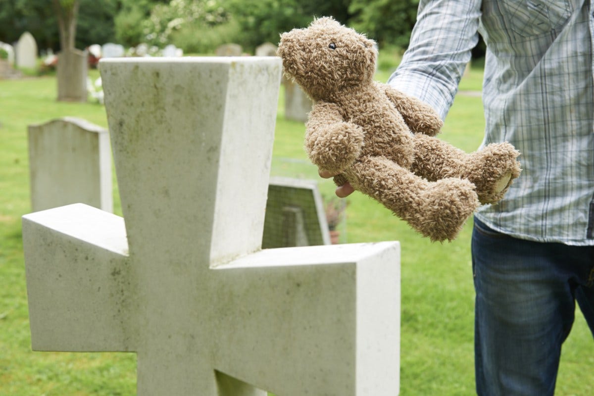 Idaho's 'faith-healing' exemption has led to more senseless child deaths | Man places teddy bear at child's grave