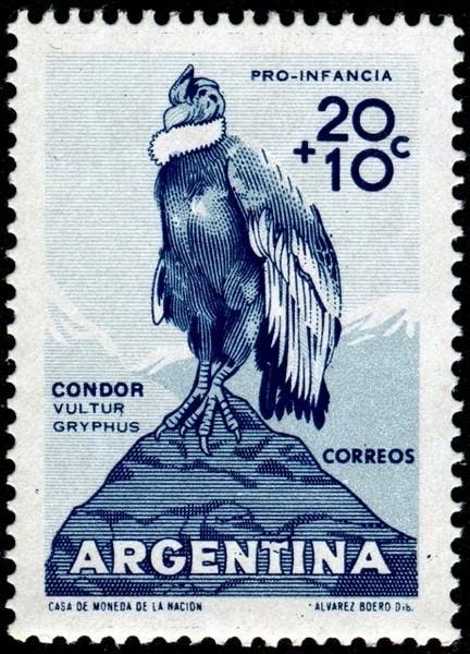 Una estampilla en tonos azules de un condor andino, encima de la cima de una montaña, con la palabra ARGENTINA en la parte inferior de la estampa. Una estampilla en tonos azules de un condor andino, encima de la cima de una montaña, con la palabra ARGENTINA en la parte inferior de la estampa.