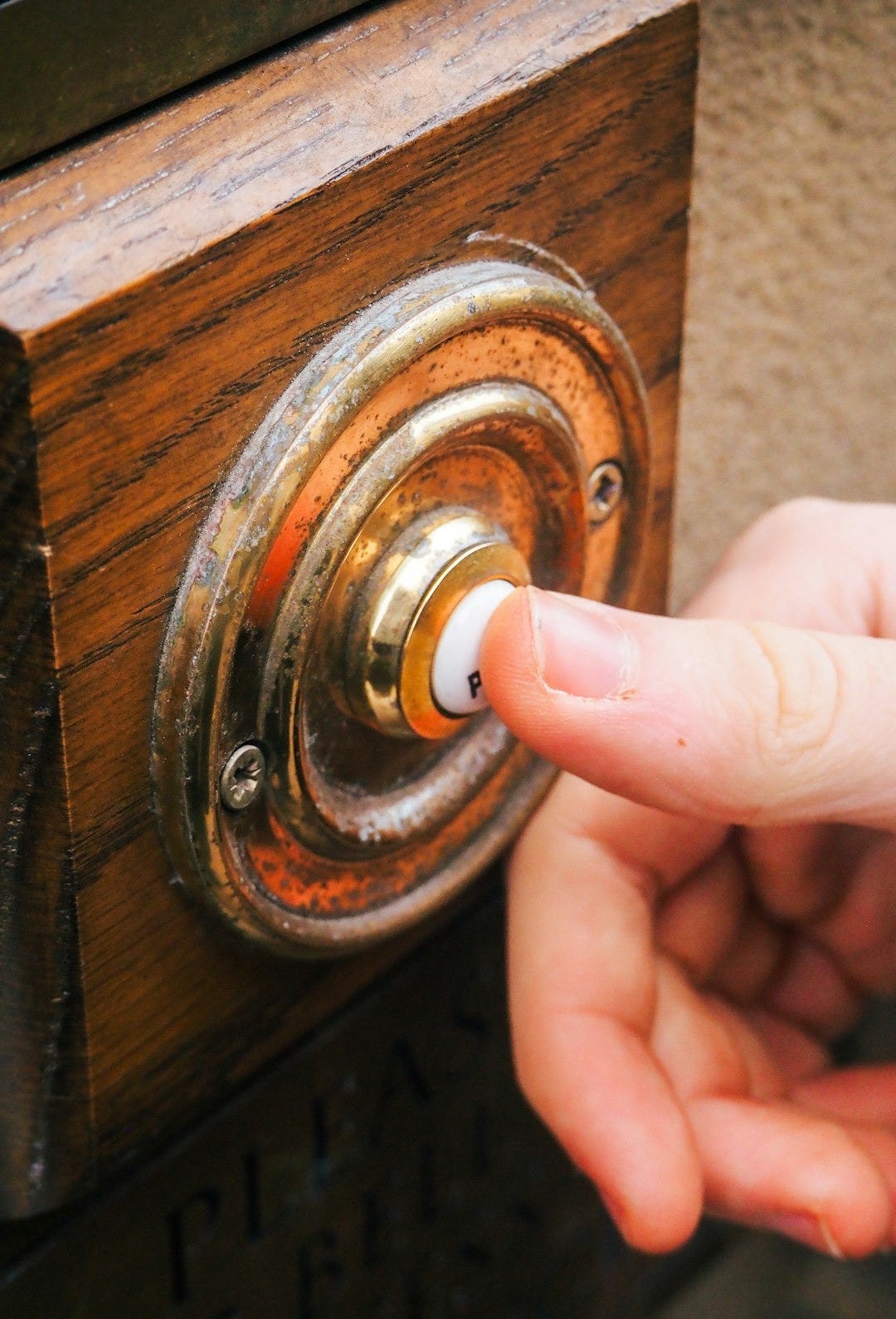 a person pressing a button on a wooden door