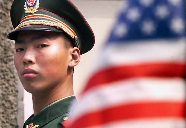 Chinese military policeman stands guard in front of the US embassy in Beijing 04 April 2001 which was heavily scarred during the NATO bombing...