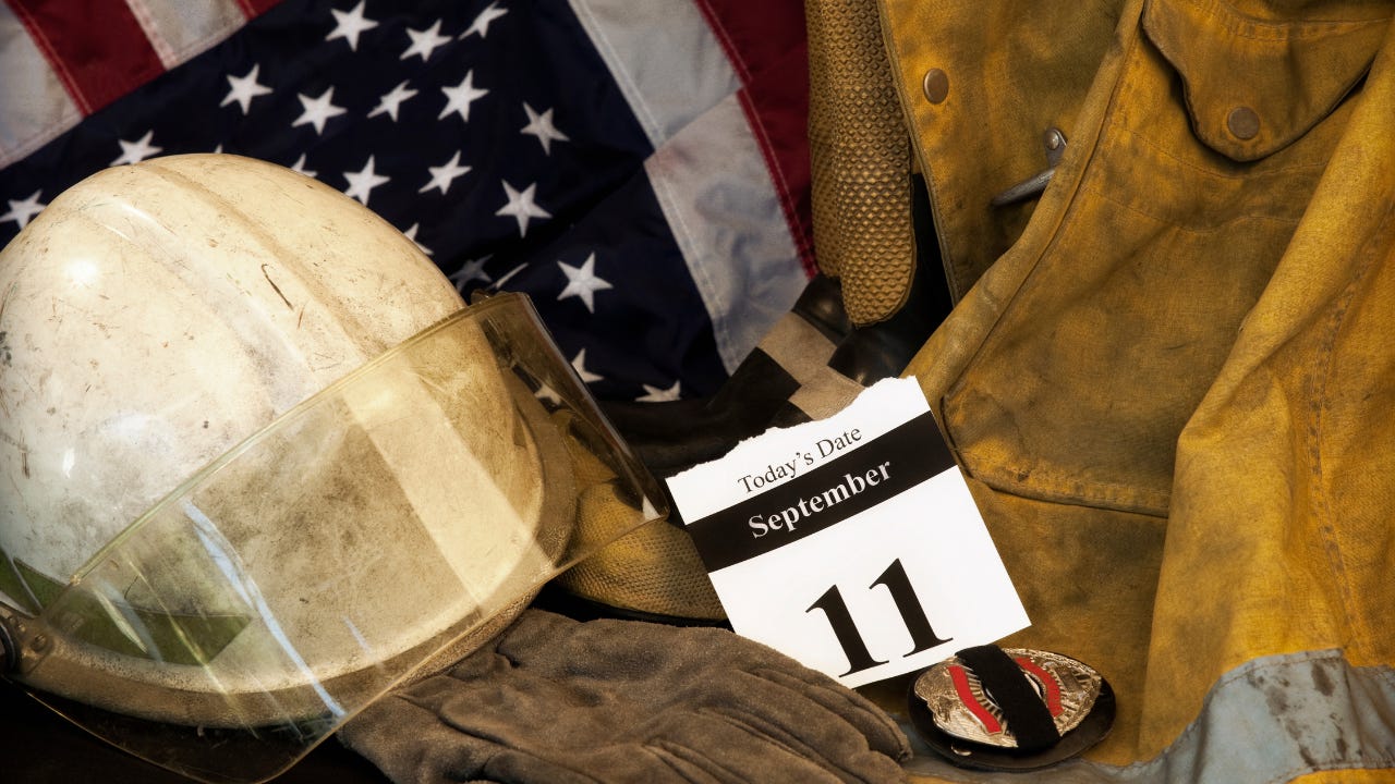 A calendar with the date of September 11 among firefighter gear and an American flag.