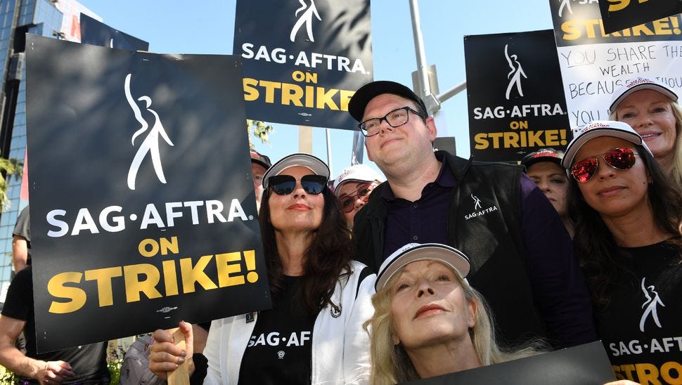 Fran Drescher (c,g), présidente du syndicat des acteurs SAG-AFTRA, et Duncan Crabtree-Ireland (c,d), directeur exécutif national, lors d'une manifestation devant les bureaux de Netflix, le 14 juillet 2023 à Los Angeles