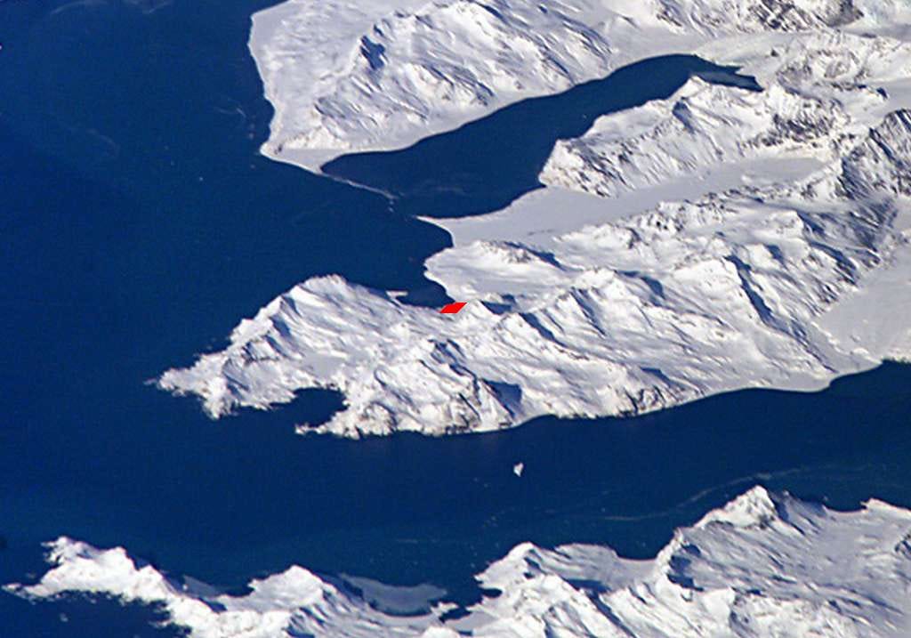 A satellite view of South Georgia with the settlement of Grytviken marked in red. The land is all white, the sea is all blue. It looks chilly.
