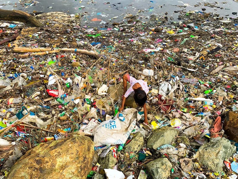 A Filipino young scavenger collects recyclable materials amongst trash along a coastline in Bacoor, south of Manila, Philippines, 19 September 2019.